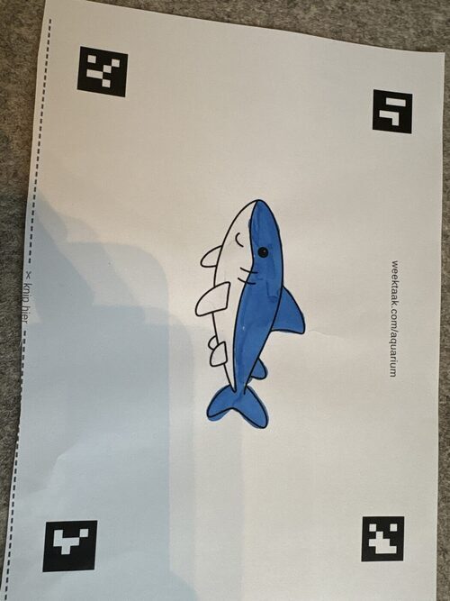 Een door een leerling ingekleurde kleurplaat van een zeedier, klaar om gescand te worden.