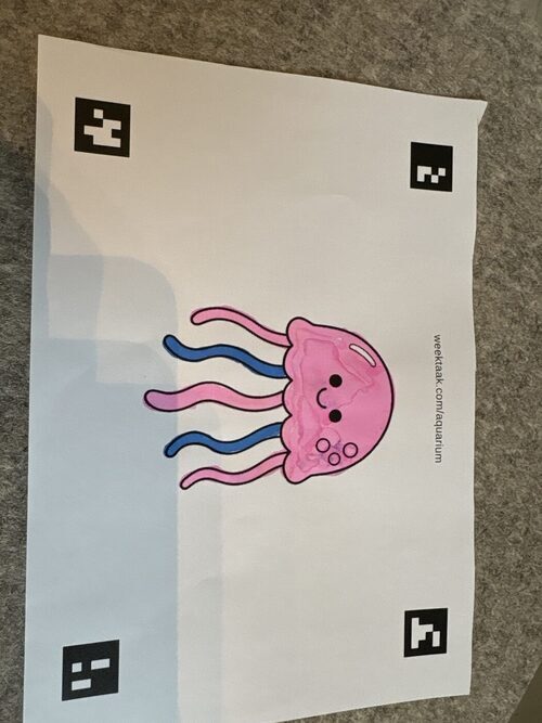 Een door een leerling ingekleurde kleurplaat van een zeedier, klaar om gescand te worden.